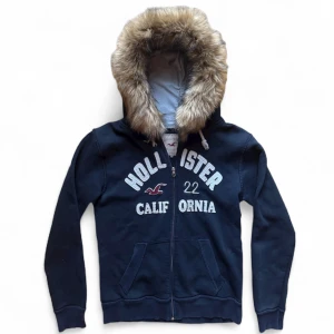 Vintage fur hoodie kofta päls hollister - Snygg populär hoodie med päls från hollister. Strl XL men passar mer en S-L beroende på önskad passform. 