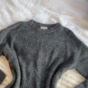 Mysig mörkgrå stickad tröja från H&M - Mysig mörkgrå stickad tröja från H&M med rund halsringning och ribbade muddar. Perfekt nu för hösten! Tröjan är i storlek 158-164 så skulle säga den passar XS.💕