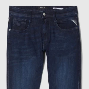 Replay jeans - mörkblå jeans från Replay med klassisk femficksdesign och diskreta Replay-detaljer på fickan. Jeansen har raka ben och normal passform, tillverkade i slitstarkt denimtyg.