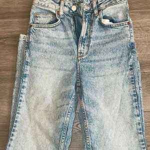 Ljusblå jeans från Never Denim - Snygga ljusblå jeans från Never Denim med klassisk femficksdesign och raka ben. Jeansen har en hög midja och är tillverkade av bomull, lyocell och lite elastan för extra komfort. Perfekt för dig som gillar en avslappnad och trendig look.