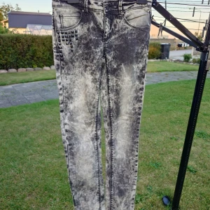 Silver Blind Fuzzy jeans med nitar - Säljer ett par grymma jeans från Silver Blind, modell Fuzzy, i tvättad svart och grå färg med coola nitar vid fickan. Skinny fit och midwaist, perfekt för dig som gillar edgy stil. Materialet är klassisk jeans och detaljerna gör dem riktigt unika.