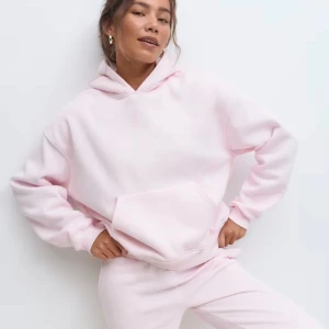 Ljusrosa hoodie med huva - Supermjuk ljusrosa hoodie med stor känguruficka och huva. Oversized passform och långa ärmar, perfekt för chill dagar. Tillverkad i skönt material som känns riktigt cozy.