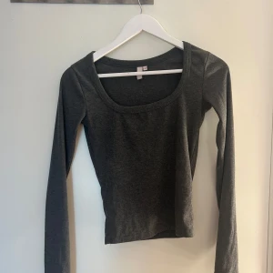 Mörkgrå ribbad långärmad topp XS - En mörkgrå, ribbad långärmad topp med rundad, djup urringning. Mycket bra skick.