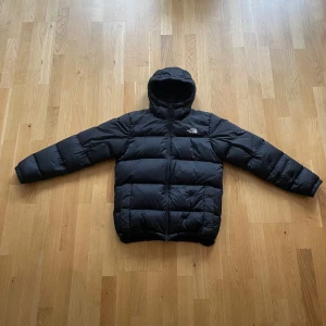 Svart dunjacka från The North Face(700) - Säljer en svart dunjacka från The North Face(700) med huva och dragkedja. Riktigt varm och skön till vintern, endast använd några fåtal gånger. Säljer då jag letar efter en ny jacka. Pris går självklart att diskutera. Storlek: medium