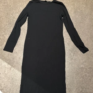 Svart långärmad klänning - En stilren svart ribbad långärmad klänning med rak passform och rund halsringning. Från lager 157 i storlek L. I princip aldrig använd . Säljer för 50kr