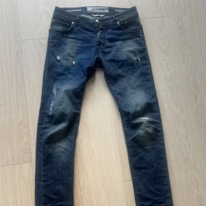 Jacob Cohen jeans - Säljer ett par Jacob Cohen jeans i modellen 622. Jeansen har en slim passform, raka ben och slitningar samt färgstänk på både fram- och baksida. Köpta från Vestiarie och äkthetsbevis finns!