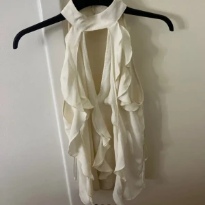 Vit topp med volanger - Säljer denna jättefina cremevita toppen från Zara. Den är bara använd 2-3 gånger 