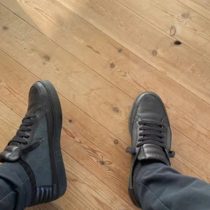 Svarta GG sneakers  i skinn - Snygga svarta sneakers f med klassisk låg profil. Skorna har ovandel i skinn och textil, svarta snören och diskret logga på plösen. Perfekta för dig som gillar stilrena och exklusiva sneakers med en lyxig känsla. För mer bilder och information tveka inte att höra av dig  tar byten