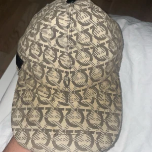 Feregamo keps  - Snygg vit  keps med vit grafiskt mönster Märke Feregamo äkta väldigt fin keps har tröttnat på den ganska mycket så den säljs eller byts mot något !