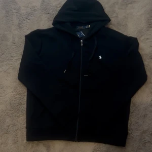  Polo zip up svart  - Polo Zip-Up Hoodie – Storlek M  ✅  – tag kvar, men kvitto saknas 🧼 Helt oanvänd – inga märken, fläckar eller skador 📦 Originalpåse saknas, men skickas väl emballerad  ⚠️ Säljes p.g.a. fel storlek 📍 Möts upp i Göteborg eller skickas spårbart  Skicka ett meddelande om du är intresserad eller har frågor!