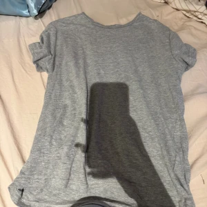 Grå t-shirt från 157 i XS - En enkel grå t-shirt från 157 i storlek XS. T-shirten har rund hals och korta ärmar, tillverkad i mjuk bomull med lite viskos för extra komfort. Perfekt för en chill och avslappnad stil.