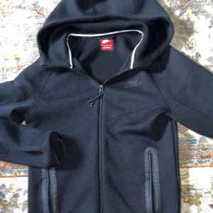 Nike tracksuit  - Svarta mjukisbyxor från Nike med dragkedjeförsedda fickor och diskret Nike-logga på ena benet. Byxorna har resår och snörning i midjan för skön passform. Perfekta för chill eller träning, tillverkade i mjukt material som känns riktigt bekvämt. Nypris 2900 