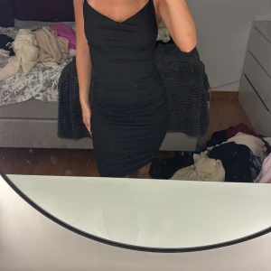 Svart tight kortklänning med smala band - Säljer en svart, tight kortklänning med smala axelband som korsas i ryggen i storlek xs