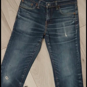 Blå jeans med slitningar - Snygga blå jeans med slitningar och lätt tvättad look. Byxorna har raka ben och klassisk femficksdesign. Perfekta för dig som gillar en avslappnad och trendig stil.