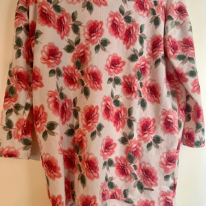 Blommig tröja från Hailys - Supersöt tröja från Hailys med blommigt mönster i rosa och grönt på vitt. Tröjan har trekvartsärm och är i mjukt material. Skickas 1-2 dagar efter genomförd betalning!