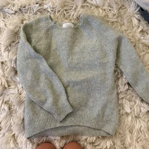 ljusgrön stickad tröja från Zara - Mysig ljusgrön stickad tröja från Zara med rund halsringning och ribbade muddar. Perfekt för kyliga dagar och enkel att matcha med jeans eller kjol. Klassisk modell med lång ärm och mjuk känsla.