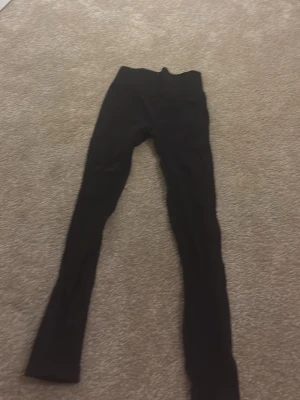 Svarta leggings från New Apparel XS - Svarta leggings från New Apparel i storlek XS, 32/34. De har en tight passform och är gjorda i ett stretchigt material som sitter skönt mot kroppen. Perfekta för dig som gillar en enkel och stilren look.