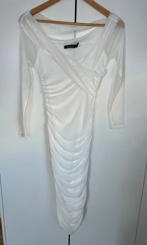 Vit långklänning från Boohoo - Säljer en elegant vit långklänning från Boohoo i storlek 34. Materialet är mjukt och silkigt. 