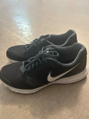 Svarta Nike löpskor - Dessa Nike Löparskor kommer att ta din löpning/promenad till en ny nivå! Med greppsanpassad sula tar du varje steg stadigt och det andningsbara tyget reglerar temperaturen på dina fötter. Detta möjliggör bekvämlig motion som inte sliter på dina knän eller leder!🤩  Dessa har endast prövats (tyvärr ute i regn).  Hör av dig för vidare frågor🤗