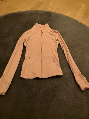 Lululemon define jacket - Snygg ljusrosa zip-jacka från Lululemon i färgen haze rose pink (ifall man vill söka upp hur den ser ut i bättre ljus)! Superfin och perfekt att springa och träna i! Använt endast 3 gånger!