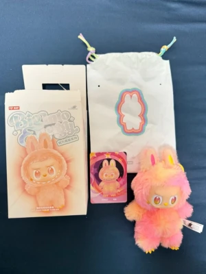 Färgglad pälsväst från The Monsters - Säljer en fluffig och färgglad nyckelring från The Monsters i rosa, orange oxh gul. Märkt med Pop Mart och kommer med originalförpackning och påse. 