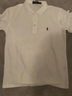 Vit piké från Polo Ralph Lauren - Säljer en klassisk vit pikétröja från Polo Ralph lauren. Perfekt för en clean och stilren look. 10/10 skick använd 1 gång! Var inte rädd för att ställa frågor!