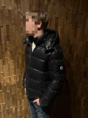 Svart moncler Maya  - Säljer nu min moncler maya! Bild 1 och 2, har modellen endas T-shirt, bild 3 och 4 tjock-tröja under! Mayan är i storlek 2 och modellen är 180 cm lång och väger 73kg! Vid köp medföljer (två olika dust-bags, en stor och en mindre. Samt lapparna och extra knappar) hör av dig vid minsta fråga eller om du vill ha mer bilder på lappar eller jackan! Pris går att diskutera! 