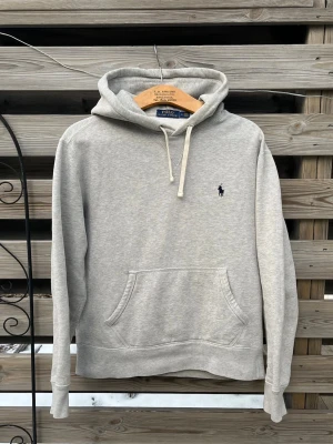 Grå Ralph Lauren Hoodie  - Snygg Grå Ralph Lauren Hoodie i storlek M, men passar mer som en XS eller mindre S. Fint skick. Hör gärna av er vid funderingar🙌Perfekt för vinterkylan☃️🌟