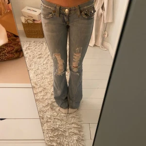 INTRESSEKOLL Vintage True Religion - INTRESSEKOLL på ett par ikoniska True Religion jeans i ljusblå med hål. Skriv gärna om ni har några frågor eller prisförslag. Innerbenslängden är 81 cm och midjemåttet rakt över är 39 cm. De är upplagda så de passar mig som är 168cm. 