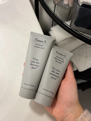 Emma S. enzyme peel & niacinamide - Två grå tuber från Emma S. – en enzyme peel som ger extra glow och en niacinamide formula för klar hud och mindre porer. Båda tuberna är stilrena med svart text och har praktisk skruvkork. Perfekt för dig som vill boosta din hudvårdsrutin.
