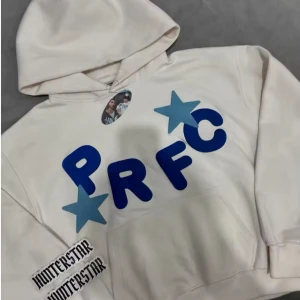 Vit hoodie Chambre de Preface - Säljer en vit hoodie från Chambre de Preface med blåa tryck och stjärndetaljer. Hoodien har stor huva med text, känguruficka och coola grafiska bokstäver framtill. Perfekt för dig som gillar streetwear vibes och unika prints. Två olika hoodies s-xl