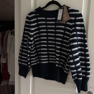 Randig stickad tröja från Vero Moda - Mörkblå och vit randig stickad tröja från Vero Moda. Helt ny ock oandvänd nypris 370kr