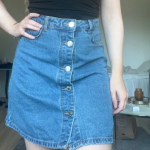 Medellång jeanskjol  - Super fin högmidjad jeanskjol, som har knappar nedifrån och hela vägen upp som knäpps ihop.  Normal i storleken. Köpt second hand men ursprungligen från Noisy May. Väldigt bra skick