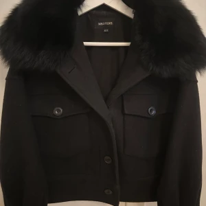 Meotine jacka svart - Säljer en svart päls kappa från Meotine i storlek XS/S. Modellen heter Charlie jacket wool black. Pälsen kan man ta av, skriv för frågor🩷