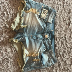 Blå jeansshorts med pärlor och fransar - Snygga low waist shorts, vet inte vart dom är ifrån. Passar storlek xs-s, ganska stretchigt material🩷
