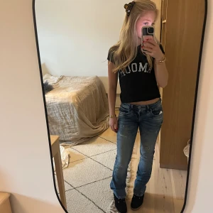 Svart croppad t-shirt med tryck - Svart croppad t-shirt med vit text framtill. Skönt material och nästan aldrig använd! Skriv för eventuella frågor, priset kan diskuteras❤️