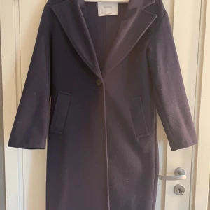 Mörkblå kappa från Bershka XS - Säljer en stilren mörkblå kappa från Bershka i storlek XS. Klassisk modell med krage, en knapp framtill och två fickor. Långärmad och rak passform, perfekt för dig som gillar en clean och tidlös look. Ordinarie pris 399kr och finns inte tillgänglig på hemsidor längre 😊