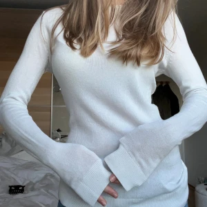 Finstickad vit långärmad tröja - Enkel och stilren vit stickad tröja med rund hals och långa ärmar. Tröjan har en slim passform och ribbade kanter vid ärmslut och nederkant. Från lager 157. Perfekt att matcha med jeans eller kjol för en clean look. Aldrig använd!! 