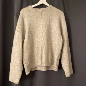 Beige stickad tröja från BikBok - Mysig beige stickad tröja från BikBok i ullblandning. Tröjan har en rak passform, ribbade muddar och lång ärm. Perfekt för lager-på-lager och chill dagar. Enkel och stilren design som funkar till allt.