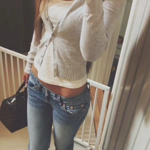 Ljusblå bootcut jeans G-Rise XS - Snygga ljusblå jeans från G-Rise i bootcut-modell med låg midja. Jeansen har klassisk femficksdesign, slitningar och lätt tvättad look. Perfekt passform för dig som gillar en lite retro vibe och vill ha jeans som sitter tajt upptill och släpper vid benen. Xs/short