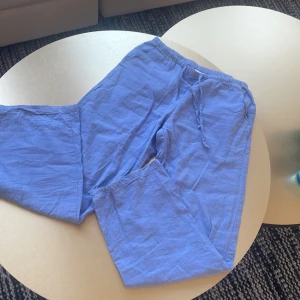 Blå linnebyxor med snörning - Säljer ett par chill blå linnebyxor med resår och snörning i midjan. Byxorna har raka ben och är perfekta för varma dagar. Lätta och luftiga, passar skönt till sommaren.