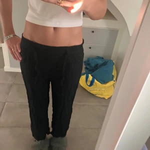 Svarta linnebyxor från Kappahl - Svarta linnebyxor från Kappahl med avslappnad passform och resår i midjan. Byxorna har raka ben och är croppade i modellen, vilket ger en chill vibe. Dom är lite korta på mig som är 168 ich. Brukar vika ner för att ha mer low-waist