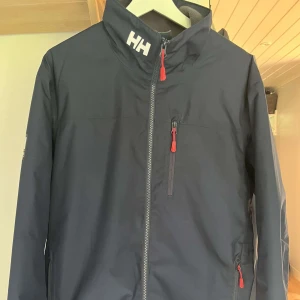 Helly Hansen jacka  - En mörkblå Helly Hansen jacka i nyskick jackan är knappt använd och det ser man på den. Hör av er vid fler frågor och bilder. 