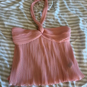  rosa halterneck topp - Supersöt rosa halterneck topp med plisserat tyg och twistad detalj vid halsen. Aldrig använd då den var för liten, den är st M men mer som en S💗 Zara liknande tröja 