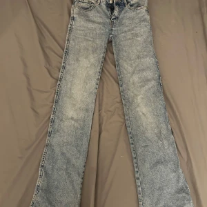 Ljusblå bootcut jeans från 157 - Snygga ljusblå jeans från 157 med bootcut passform och klassisk femficksdesign. Jeansen har slitna detaljer och en tvättad look som ger en cool vintagekänsla. Tillverkade i bomull för en skön känsla och perfekt för dig som gillar retrostil. Storlek XS Tall. Kostade ungefär 300 på lager 157.