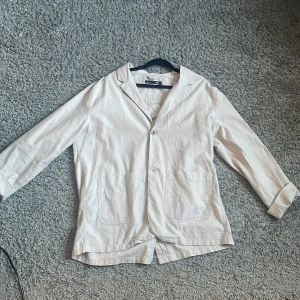 Beige overshirt från 157, storlek M - Säljer en stilren beige overshirt från 157 i storlek M. Riktigt schysst och använd fåtal gånger. Perfekt att ha för en najs look.