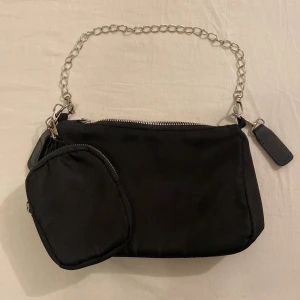 Svart axelväska med kedja och mini-väska - Snygg svart axelväska med tillhörande liten mini väska. Använt 1-2 gånger. Mycket bra skick.