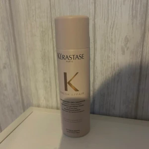 Kérastase Fresh Affair torrschampo - Kérastase Fresh Affair torrschampo i en stilren beige sprayflaska med gulddetaljer. Perfekt för att fräscha upp håret mellan tvättarna och ge en lätt, fräsch doft. Innehåller vitamin E och risstärkelse. Snygg och praktisk för badrumshyllan.