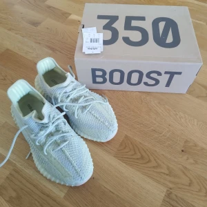 Adidas Yeezy Boost 350 V2 Antia sneakers (non reflective) - Säljer ett par Adidas Yeezy Boost 350 V2 sneakers i ljusgrått. Skorna har stickad ovandel, rund tå och snörning. Sulan är vit och ribbad, och insidan har Adidas Yeezy-logga. Perfekta för dig som gillar stilrena och bekväma sneakers. Använda endast 2 gånger.