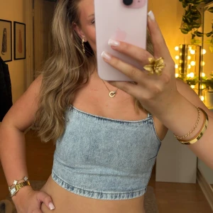 Ljusblå jeans bandeau topp - Säljer en ljusblå croppad bandeau topp i jeansmaterial med axelband och dragkedja i ryggen. Toppen har en tight och kortare passform. Jätte fin jeansfärg. Säljer då den är för liten för mig. Storlek xxs men passar även xs. Läs bio innnan köp. Ej använd alls.
